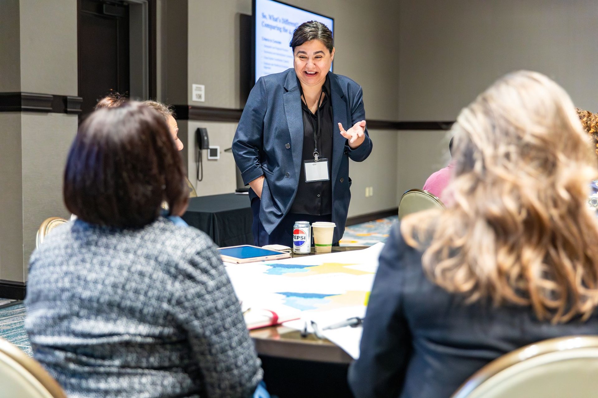 A facilitator speaking with participants during a small-group mapping activity